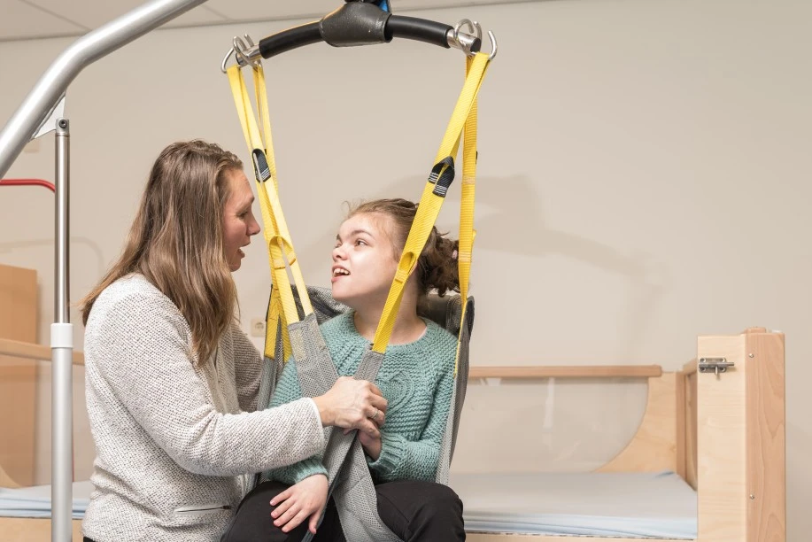 Nurse with disabled girl in hoist
